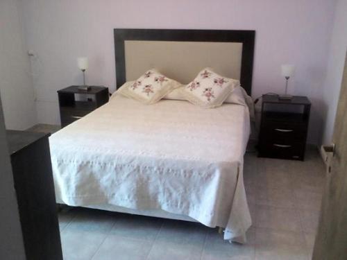 1 dormitorio con 1 cama grande y 2 mesitas de noche en Mi Chalet Carlos Paz - Dúplex en Villa Santa Cruz del Lago