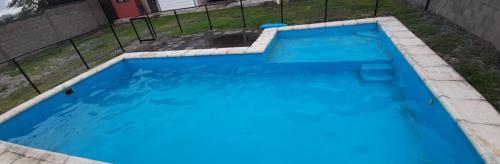 una gran piscina azul en un patio en Mi Chalet Carlos Paz - Dúplex en Villa Santa Cruz del Lago