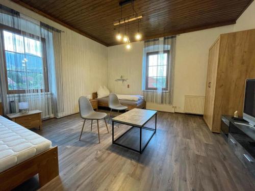 - un salon avec un lit, une table et des chaises dans l'établissement Villa Ganzstein Appartement, à Mürzzuschlag