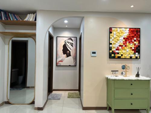 La salle de bains est pourvue d'une commode verte et d'une peinture murale. dans l'établissement UPhoenix Home- HaDo Centrosa Garden, à Hô-Chi-Minh-Ville