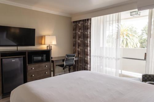 a hotel room with a bed and a large window at Travelodge by Wyndham Monterey Bay in Monterey