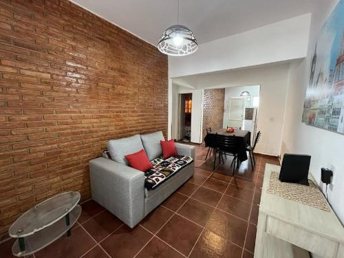un soggiorno con divano e muro di mattoni di Departamento Fatima a Villa Dolores