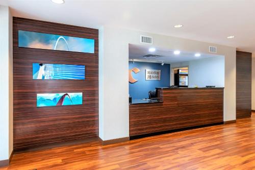 un vestíbulo de oficina con puertas correderas de madera en MainStay Suites St Louis Airport en Bridgeton