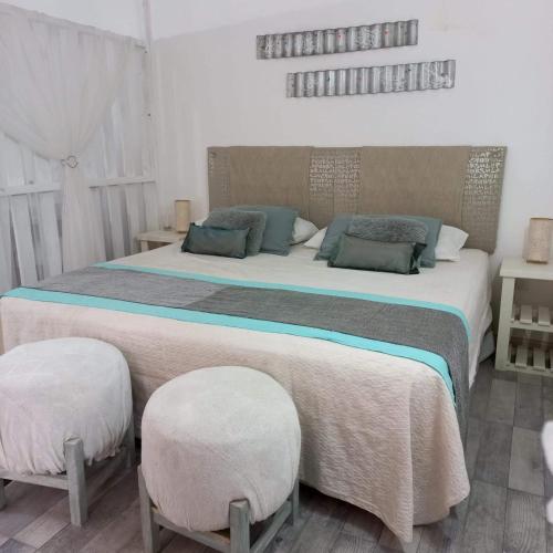 a bedroom with two beds and two stools at Alamo in Pinamar