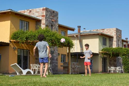 two young boys playing with a soccer ball in a yard at Magas de Drummond in Mayor Drumond