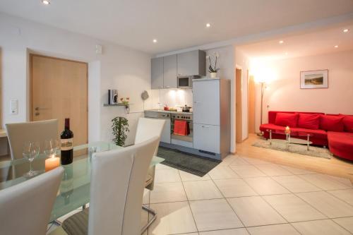 a kitchen and a living room with a red couch at Apart Hofer in Nauders