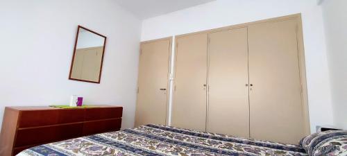 - une chambre avec un lit, une commode et un miroir dans l'établissement Depto Microcentro exelente ubicación, à Mar del Plata