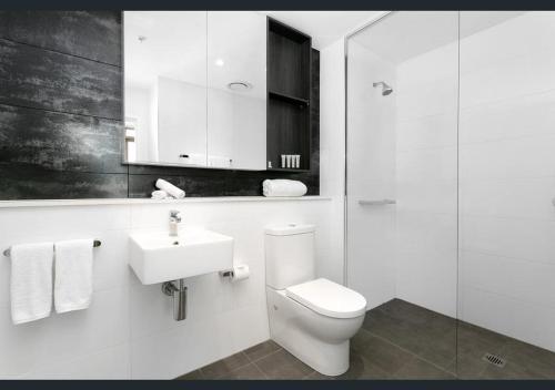 uma casa de banho branca com um WC e um lavatório em Premium Apartments Chatswood em Sidney