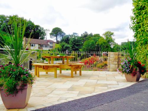 a patio with a wooden table and potted plants at The Gateway Lodge in Donegal