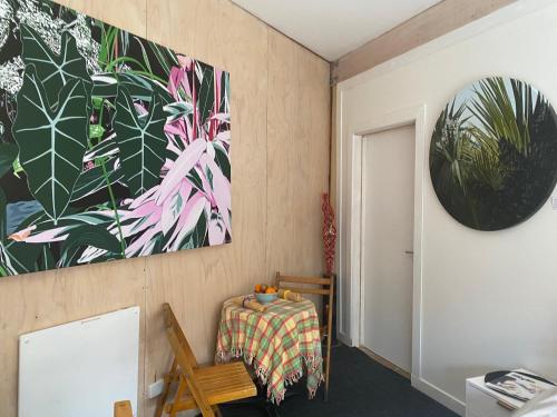 una habitación con una mesa y una pintura en la pared en Stay at the art gallery en Mapua