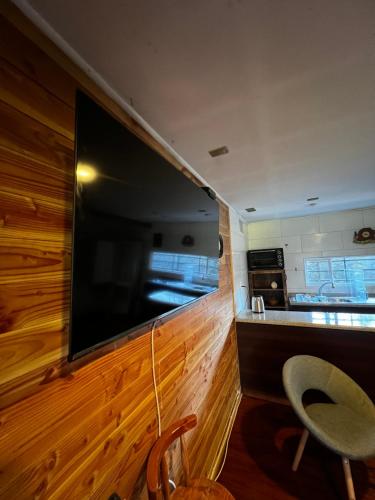 a large flat screen tv on the wall of a kitchen at Cabaña El Nativo - Licán Ray in Licán Ray