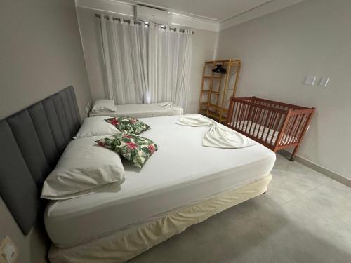 um quarto com 2 camas e um berço em Casa da Jana com piscina em Porto Seguro