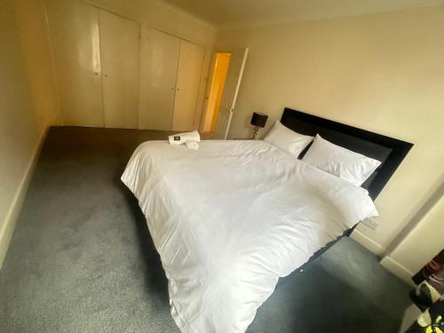 ロンドンにあるEdgware Road apartmentのベッドルーム1室(白いシーツと枕のベッド1台付)