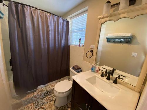 uma casa de banho com um lavatório, um WC e um chuveiro em Bunkhouse at the Silver Spur Dancehall Ruins~Bandera, TX. em Bandera
