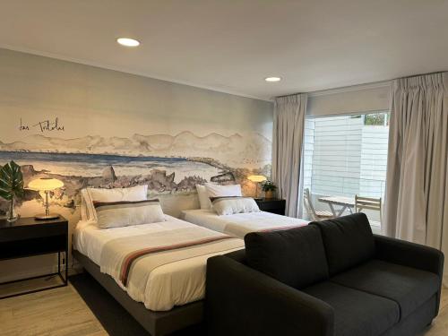 タルタルにあるNolana hotelのベッドルーム1室(ベッド2台、ソファ付)