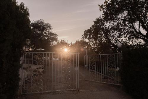 a gate with the sun shining behind it at NOUS in Agel