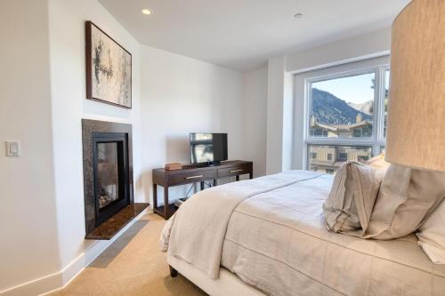 a bedroom with a bed and a window and a desk at Luxe Ketchum Penthouse with Rooftop Hot Tub in Ketchum