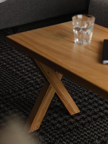 a wooden coffee table with a glass on it at m hotel in Sale