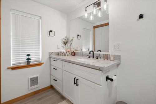 La salle de bains blanche est pourvue d'un lavabo et d'un miroir. dans l'établissement Cozy Pines, à Ashford