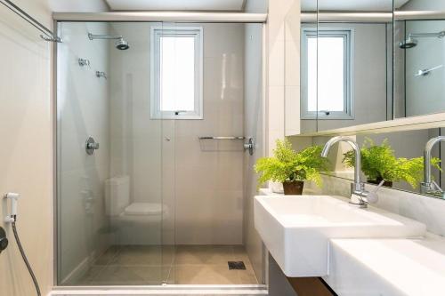 Un baño con ducha, lavabo y espejo. en Condominio Quay Luxury, en Florianópolis
