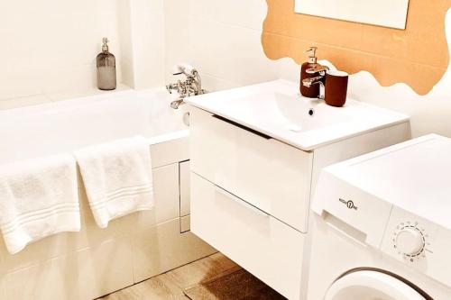 een witte badkamer met een wastafel en een toilet bij Le chic appartement de Gagny/parking gratuit in Gagny