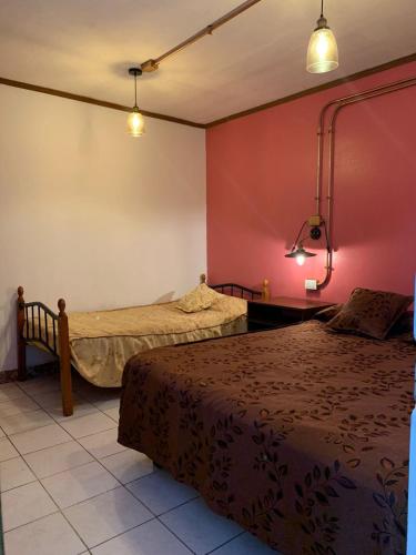duas camas num quarto com paredes vermelhas em Residencial La Piramide em Iquique