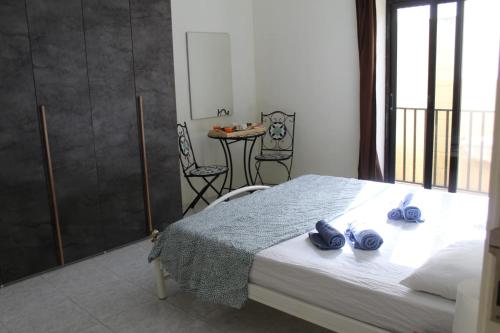 sypialnia z łóżkiem z dwoma niebieskimi ręcznikami w obiekcie Le 3 isole w mieście Marsaskala