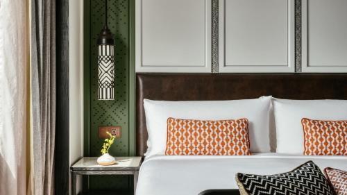 a bedroom with a bed with orange and white pillows at InterContinental Chiang Mai The Mae Ping in Chiang Mai