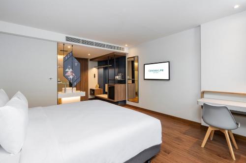 a bedroom with a white bed and a desk and a chair at Centara Life Hotel Bangkok Phra Nakhon in Bangkok
