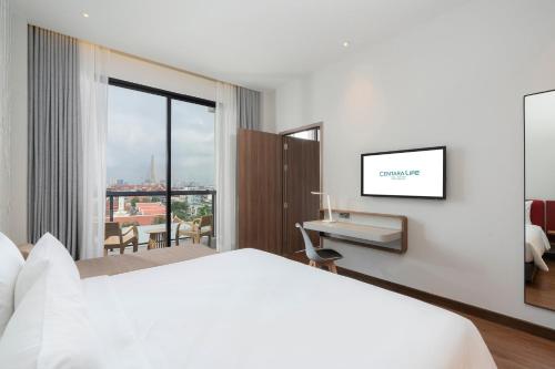 a hotel room with a bed and a desk with a view at Centara Life Hotel Bangkok Phra Nakhon in Bangkok
