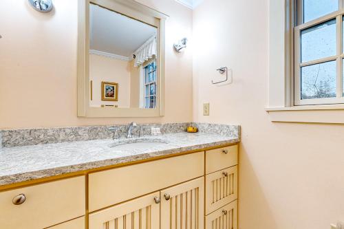 a bathroom with a sink and a mirror at Sugarwood Farmhouse in Wilmington