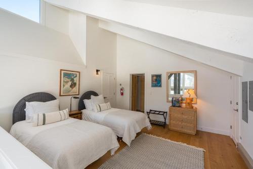 two beds in a room with white walls at Just Remodeled! The Big Wood Retreat with a Loft in Sun Valley