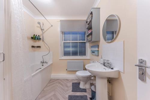 a bathroom with a sink and a toilet and a mirror at property discarded in London