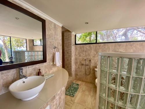 a bathroom with a sink and a mirror at Boutique Beachfront Hotel on Isla Contadora in Contadora