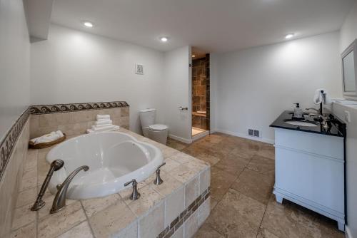 a bathroom with a large tub and a sink at Oceanfront Villa in Ladysmith