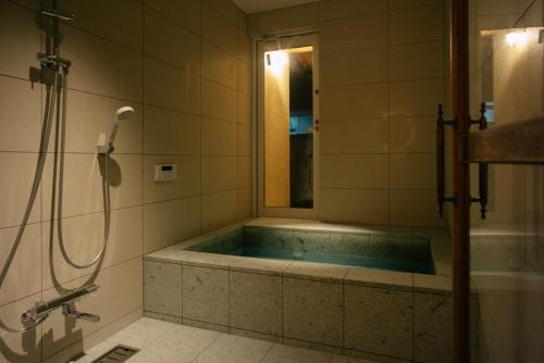 La salle de bains est pourvue d'une baignoire et d'une douche. dans l'établissement willow., à Toyooka