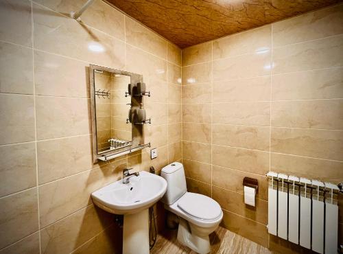 a bathroom with a white toilet and a sink at Nuray's House in Sheki