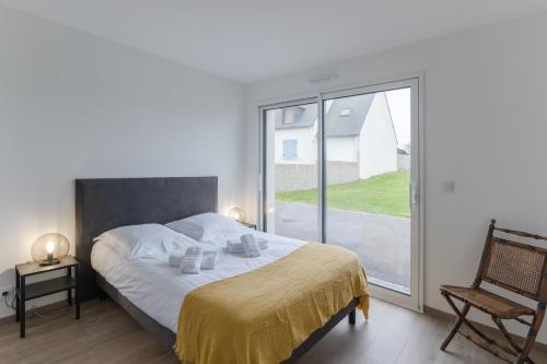 ein Schlafzimmer mit einem Bett und einem großen Fenster in der Unterkunft KER STIVELL - Superbe maison neuve à 2 pas de la mer in Landunvez