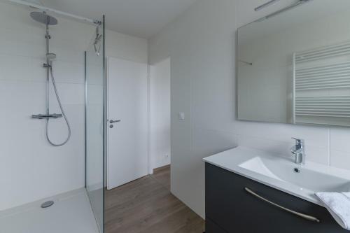 a white bathroom with a sink and a shower at KER STIVELL - Superbe maison neuve à 2 pas de la mer in Landunvez