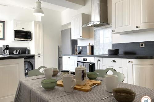 - une cuisine avec une table et des bols verts dans l'établissement La Catène - Balcon - Vue Catène, au Havre