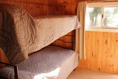 ポトレリージョスにあるCabaña El Bosquecito con vista al diqueの窓付きの木製の部屋の二段ベッド1台分です。