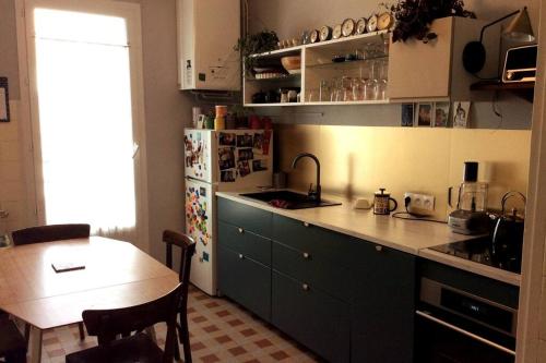 uma cozinha com uma mesa e um frigorífico em Appt 90 m2, quartier tranquille em Grenoble