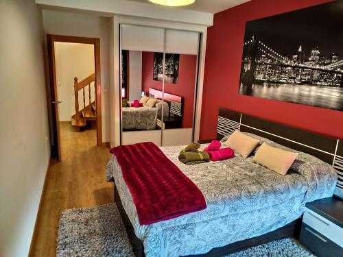 1 dormitorio con 1 cama con pared roja en Casa Nicolas, en Chantada