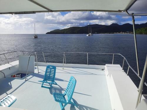 zwei Stühle auf dem Deck eines Bootes in der Unterkunft L'aquahome hébergement sur l'eau in Les Trois-Îlets