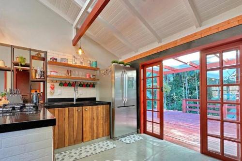 a kitchen with a refrigerator and wooden cabinets at Jardins da Vila - Farm house in Blumenau