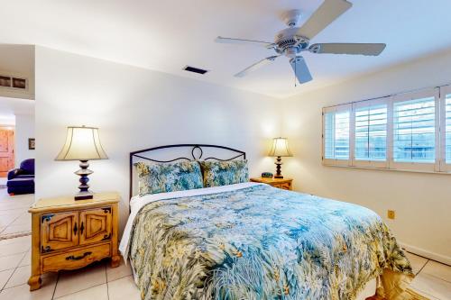 a bedroom with a bed and a ceiling fan at Aqua Parrot in Largo