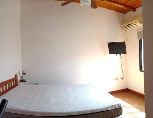 a bedroom with a bed and a tv on the wall at El Aura in Colón