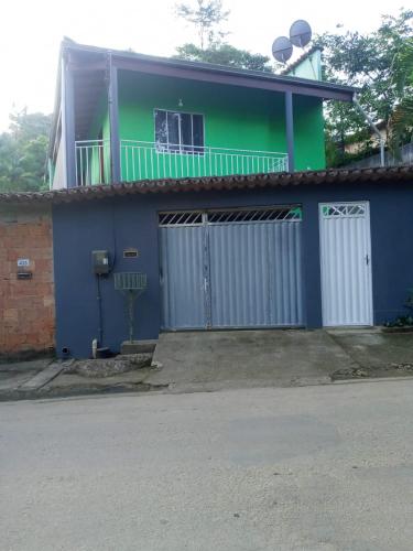 a blue and green house with a building at Pouso AJH in Paraty