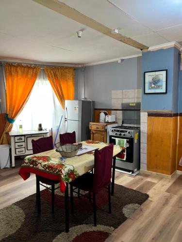 uma cozinha com uma mesa com cadeiras e um fogão em Casa central en Punta Arenas em Punta Arenas