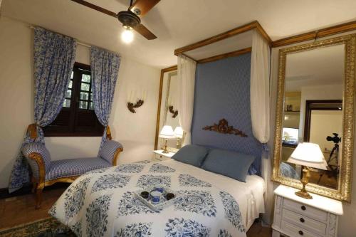 a bedroom with a blue and white bed and a mirror at Casas Park Way in Brasilia